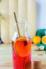 Hot tea with orange and ginger on a wooden Board toning.