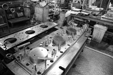 Sheet Metal Stamping Tool Die. Progressive Stamping System. Black and White Photography.