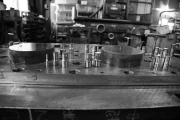 Sheet Metal Stamping Tool Die. Progressive Stamping System. Black and White Photography.