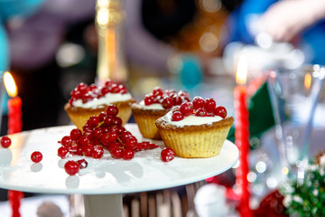 Christmas dessert - cream puffs and red currants on a background