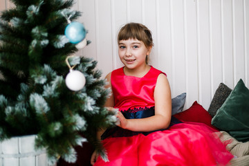 portrait of a girl in a red dress at the Christmas tree - 129197245