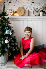 portrait of a girl in a red dress at the Christmas tree - 129197249