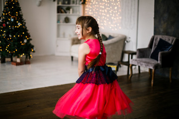 portrait of a girl in a red dress at the Christmas tree - 129197254