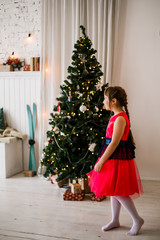 portrait of a girl in a red dress at the Christmas tree - 129197258