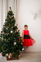 portrait of a girl in a red dress at the Christmas tree - 129197259