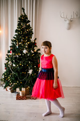 portrait of a girl in a red dress at the Christmas tree - 129197263