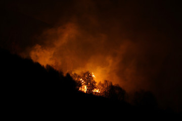 Forest fires spreading through mountains above Isone, in Switzerland