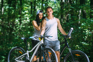 Obraz premium Young Couple Riding Bike In Park