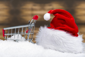 Santa Claus pushing a shopping cart full of gifts and christmas tree