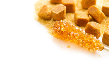 Brown amber sugar crystal on wooden stick.