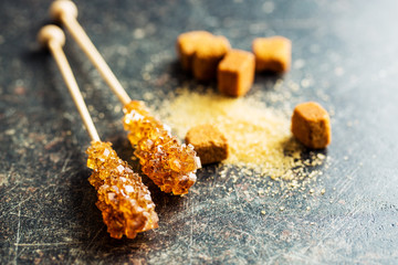 Brown amber sugar crystal on wooden stick.