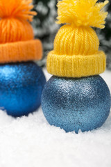 Funny Christmas background with a blue ornament with winter cap, golden gift box, Angels, berries and fir in snow on forest backround