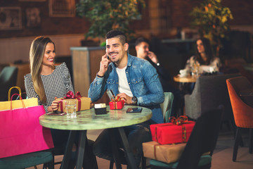 Young couple enjoying the coffee shop after Christmas shopping