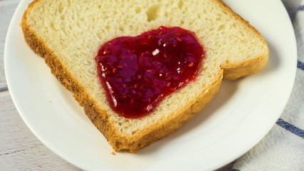 Toast with jam on wooden table.