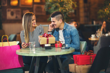 Young couple enjoying the coffee shop after Christmas shopping