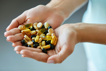 Obraz premium Vitamins And Supplements. Woman Hands Full Of Medication Pills