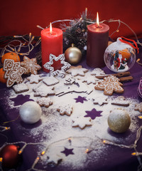 Fototapeta na wymiar Christmas gingerbread cookies with flour, toys, cinnamon, candle