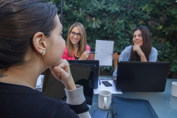 Young enterprising woman shows the other co-workers an outline on a white folio. She is explaining...