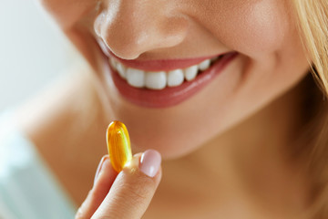 Close Up Of Beautiful Woman Taking Fish Oil Capsule In Mouth - obrazy, fototapety, plakaty