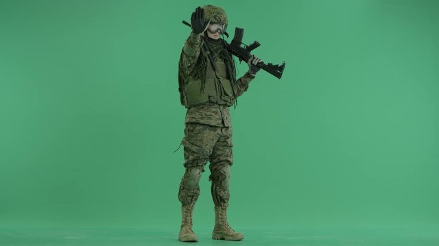 Soldier stretching hand at green screen