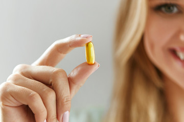 Beautiful Woman Holding Fish Oil Pill In Hand. Healthy Nutrition