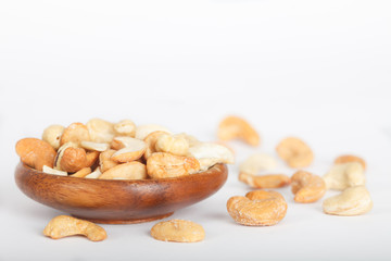 Indian nuts. Cashew nuts in wooden bowl on white background.