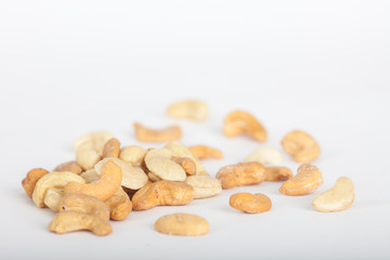 Raw and roasted cashew nuts on white background