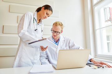 Ärztin und Arzt besprechen Krankenakte