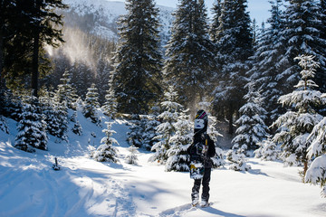 Man  climbs  winter  mountains for snowboarding on fresh snow