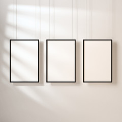 Three White posters with black frame mockup hanging on the wall with shadows, 3d rendering