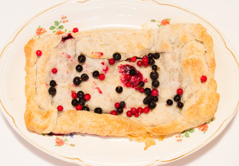 Homemade pie on a plate of berries.
