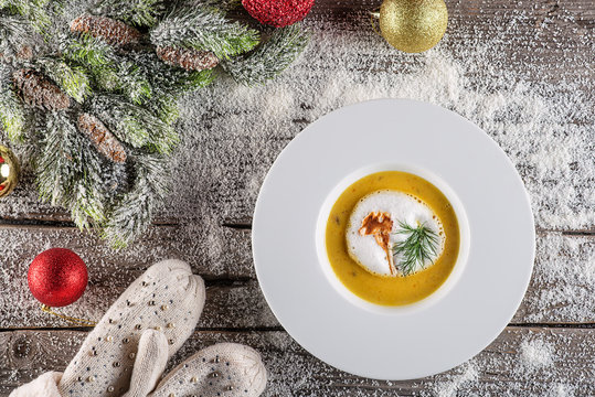 chrismas fish soup in white plate with christmas decorations, modern gastronomy