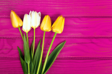 yellow tulip bouquet on pink wooden tray