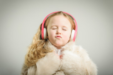 Party girl in pink fur coat and headphones.