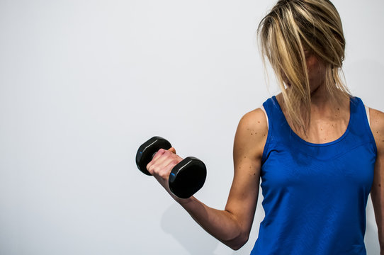 ragazza si allena in palestra facendo pesi per le braccia