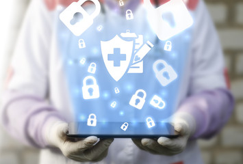 Medical health care insurance mobile virtual internet concept. Doctor holding tablet computer with shield plus clipboard pencil icon cloud lock security safety. Medicine healthcare assurance treatment