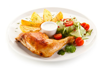 Grilled chicken legs with chips and vegetables isolated on white background