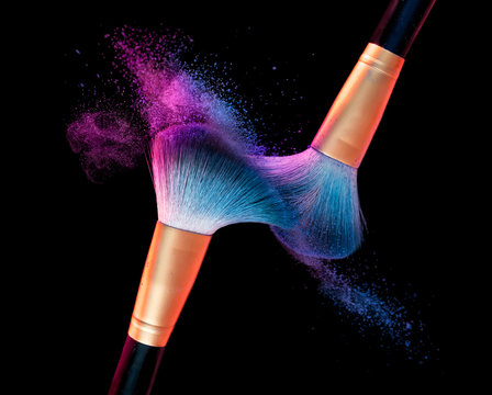 Makeup brush with blue powder explosion on black