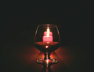 christmas composition photo cognac glass and candle on black background