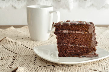 A slice of delicious chocolate cake and a mug