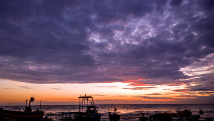 Fototapeta na wymiar Barche da pesca in partenza all'alba, con temporale in arrivo
