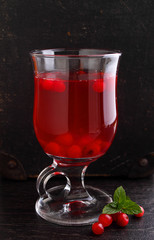 Tea with cranberries in a cup on a black background