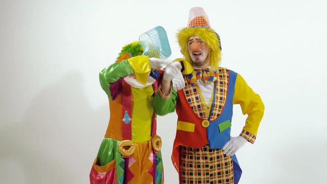 Two funny clowns singing and dancing against white background