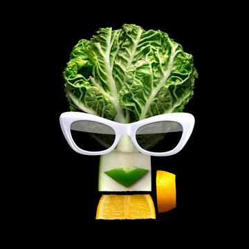 Naklejki Tasty art / Quirky food concept of cubist style female face in sunglasses made of fresh fruits on black background.