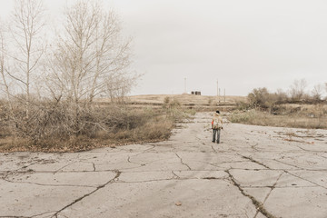 young boy with a gun in his hand. boy goes to an abandoned building. wanderer in the world of the...