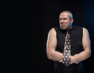 Emotional comic actor gesturing man in a tie on a black background, Christmas and New Year