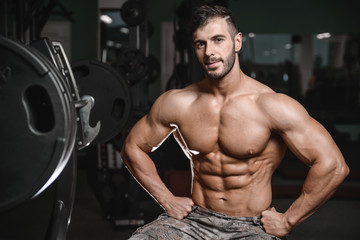 Fototapeta na wymiar Strong and handsome athletic young man muscles abs and biceps.