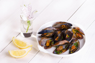 Mussels in a white plate with parsley and lemon zest