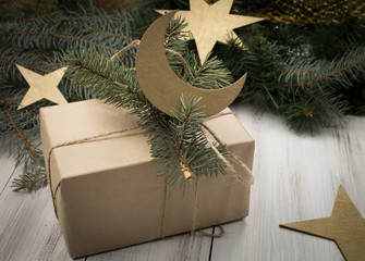 Naklejka na ściany i meble Christmas gift or present box wrapped in kraft paper with decoration on rustic wooden background.
