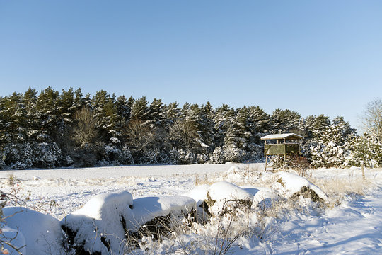 Ett jakttorn p&aring; ett sn&ouml;igt f&auml;lt